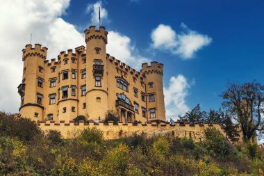 Ünlü Hohenschwangau Bavyera Şatosu ve sonbahar başlarında bulutlu gökyüzü