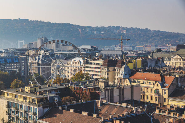 Ferris wheel and old buildings rooftop view in Budapest city center