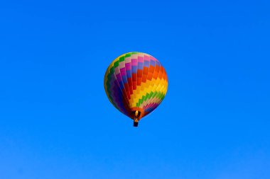 colored and huge flying air balloon on bright blue sky background
