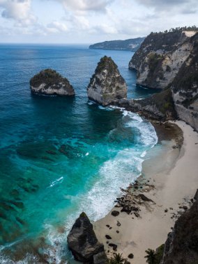 Endonezya 'nın Bali Adası' ndaki Nusa Penida plajında turkuaz suyu bulunan muhteşem kayalar ve kayalıklar.