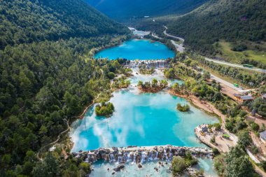 Yeşim Ejderha Kar Dağı 'nın yemyeşil vadisi boyunca uzanan mavi nehrin panoramik manzarası, Lijiang Yunnan Çin