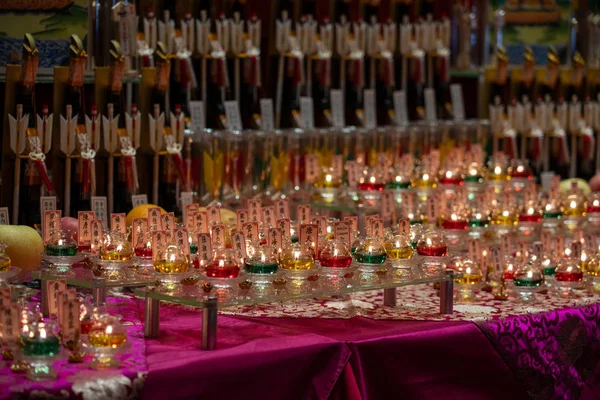 lots of burning candles on table in church background