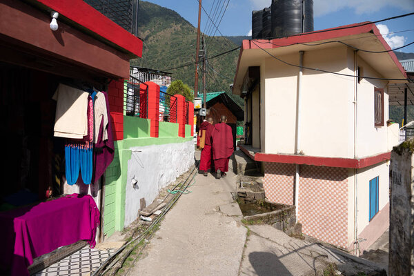 buddhist monks walking in small traditional village in northern India