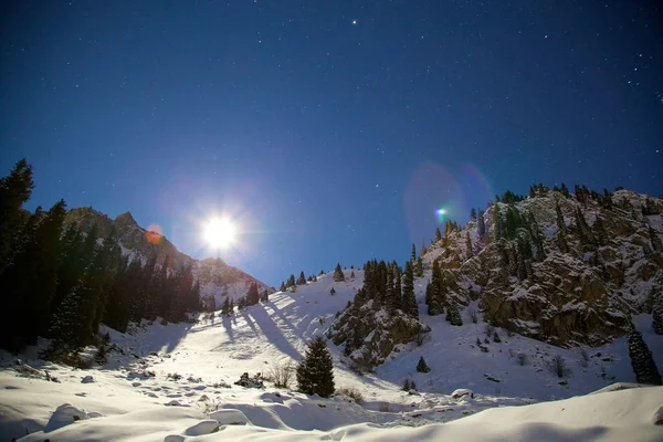 Mountains at night. View of mountain range night sky with stars and constellation of the orion in the full moon.