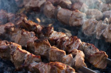 Domuz eti şiş kebap ızgarada pişirilir. Kömürlerin duman