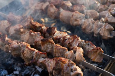 Domuz eti şiş kebap ızgarada pişirilir. Kömürlerin duman