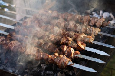 Domuz eti şiş kebap ızgarada pişirilir. Kömürlerin duman