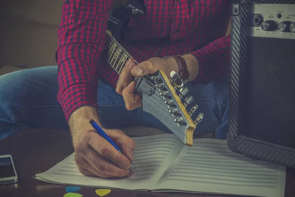 Hipster muzikant zit op de Bank met een elektrische gitaar en r — Stockfoto