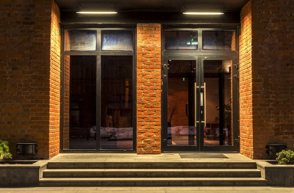 Zwei Glastüren in einem Backsteingebäude in der Nacht — Stockfoto