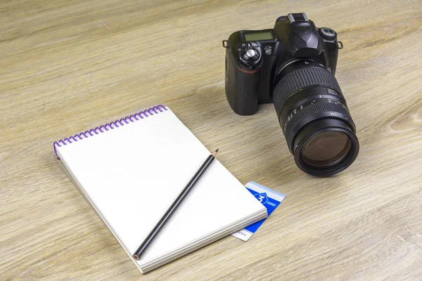 Buku catatan dengan pensil dan kamera SLR pada tekstur kayu — Stok Foto