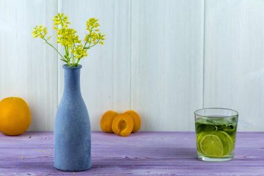 Vazo ile alan sarı çiçekler, tablo ve bir bardak Mojito kayısı