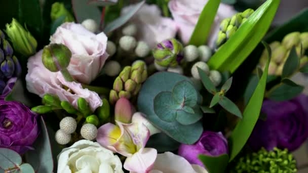 Velmi blízký pohled na bílých, růžových a fialových barevných květů. Mezi nimi růže, eustomas, hyacinty, pivoňka, brunia Pryskyřník a eukalyptu listy.