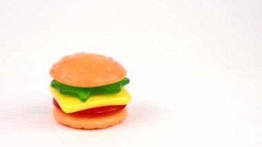 Lezzetli Mini Gummi Hamburger üzerinde dönen beyaz arka plan üzerinde izole dönüş tablo. 