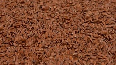 Tam çerçeve arka plan üzerinde dönen kahverengi keten tohumu tablo açın. Loopable. Makroyu kapatın. Açılı görünümü.