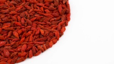 Yarım çerçeve daire üzerinde dönen organik kurutulmuş goji meyveleri yığın şeklinde tablo açın. Beyaz izole. Loopable. Makroyu kapatın. Yukarıda/ek yükü göster.