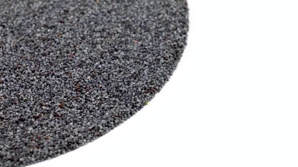 Half frame circle shaped heap of organic raw poppy seeds rotating on turn table. Isolated on white. Loopable. Close up macro. Angled view. — Stock Video