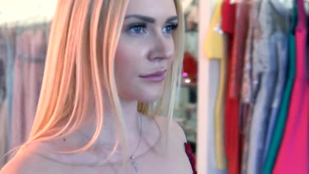 金发女郎穿着性感的红色晚礼服穿过商店 镜像中的反射 — 图库视频影像