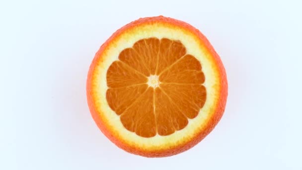 Fruta naranja cortada girando. Aislado sobre fondo blanco. Vista desde arriba / arriba. Primer plano macro . — Vídeo de stock