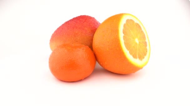 Mango, oranžové ovoce a mandarinky ovoce otočení na bílém pozadí. Izolovaný. Detailní záběr. — Stock video