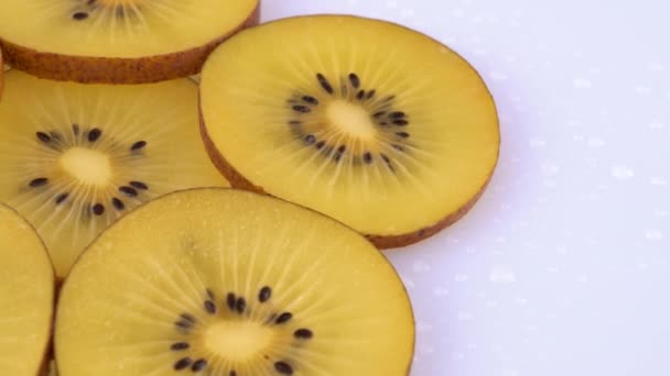 Extrémní zblízka zlaté kiwi řezy otočení na točnu. Izolované na bílém pozadí. Makro. — Stock video