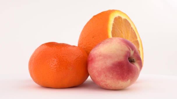 Nektarinky, oranžové ovoce a mandarinky otočení na otočném stole. Izolované na bílém. Detail. — Stock video
