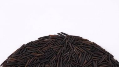 Yarım çerçeve daire ham yabani pirinç üzerinde beyaz arka plan üzerinde dönen yığını şeklinde. Loopable. Makroyu kapatın. Yukarıda/ek yükü göster.