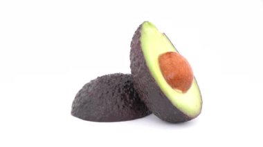 Dilimlenmiş avokado haas üzerinde yavaş yavaş döner iki bölümden tablo açın. Beyaz arka plan üzerinde izole. Makroyu kapat.