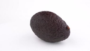 Ham Haas avakado yavaş yavaş bir dönüş tabloda döndürür. Beyaz izole. Yakın çekim makro.