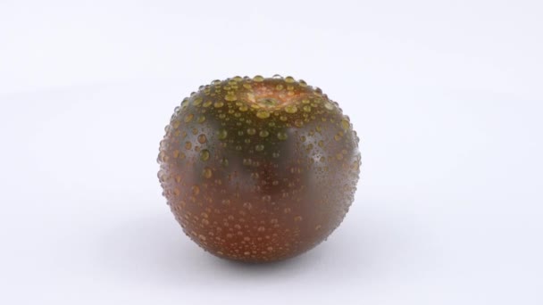 Gocce d'acqua su un pomodoro fresco (pomodoro nero) ruotavano lentamente su fondo bianco. Isolato . — Video Stock