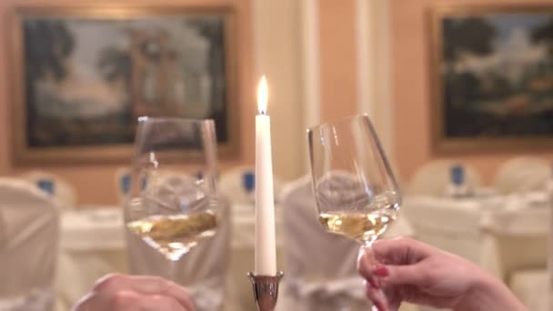 Närbild av klirrande glas. En mans och en kvinnas händer. Interiören i en fancy restaurang. — Stockvideo