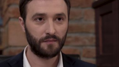 Güzel bir yemek restoran ağzına bir parça yiyecek koyarak sakallı bir adamın suratına closeup.