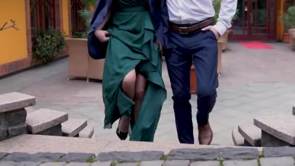Una giovane coppia sale le scale sulla terrazza del ristorante . — Video Stock