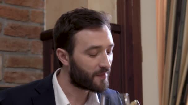 Close-up van een gast van het restaurant. Gezicht van een bebaarde man de schotel eten en zijn mond met een servet afvegen. — Stockvideo