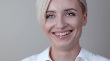 Genç sarışın kız closeup içinde kameraya güler.