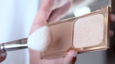 Kadın el göz gölgeler paleti tutar. İkinci el gölgeler üzerinde düz fırça smear. Portre.