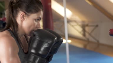 Güzel esmer kadın onu antrenman ör bir fitness spor salonu ile boks. Ağır çekim. Güçlü ve güzel bir kadın. Zor egzersiz.