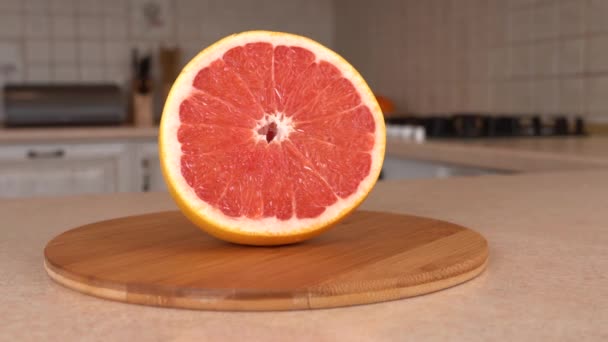 Close up of fresh pink grapefruit. Rotating camera with white kitchen on the background. Dolly-shot. — Stock Video