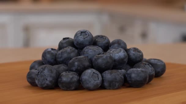 Close up of several blueberrie berries. Rotating camera with white kitchen on the background. Dolly-shot. — Stock Video