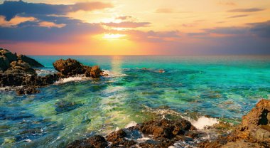 Gün batımında deniz manzaralı kayalar.