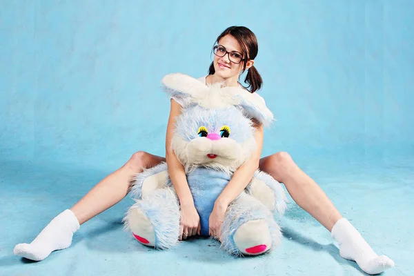 Kız bardaklarda yumuşak oyuncak tavşan ile.