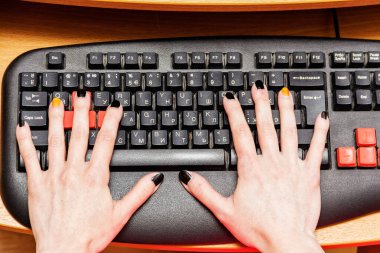 Ofiste bir kadının elleri bilgisayarın klavyesinde..