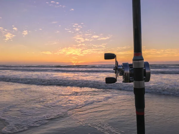 Canna da pesca sulla spiaggia al tramonto, surf cast . — Foto Stock