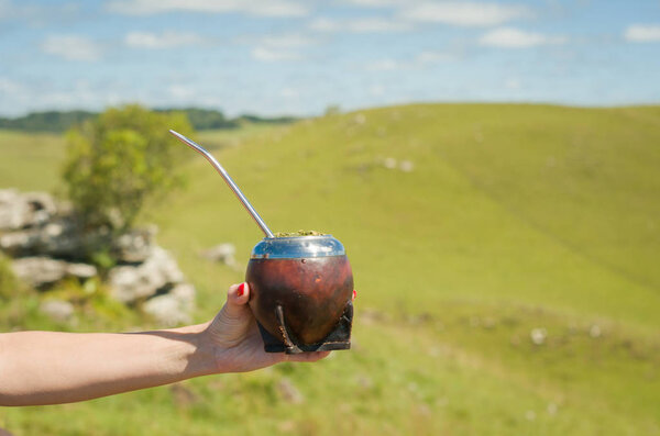 Traditional mate, mate, with green field view. (Chimarrao).