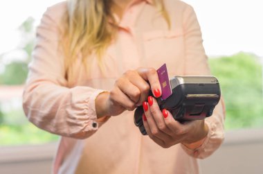 Ödeme kredi kartı, kredi kartı ile ödeme yapma makinesi üzerinde genç beyaz bir kadın ile büyük kavram.