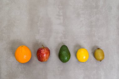 Sağlıklı yeme, gri arka plan üzerinde çeşitli meyve büyük kavram beton cilalı. Portakal, elma, kivi, limon.