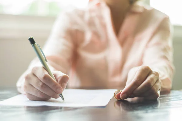 Great concept of divorce, end of relationship, young woman signing divorce agreement.