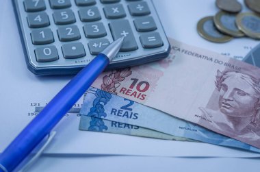 Kalem, grafikler, hesap makinesi, kredi kartı ve Brezilya para (gerçek), finans kavramı, ev ekonomisi.