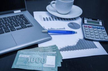 Dizüstü bilgisayar, kahve fincanı, kalem, hesap makinesi, grafikler ve para Lübnan Lirası, ekonomi kavramı, ev ekonomisi.
