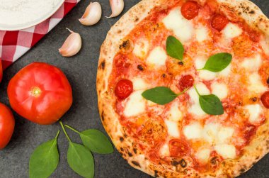 Mutfak temaları için harika bir arka plan, Marguerite aromalı ve farklı malzemeli el yapımı pizza..