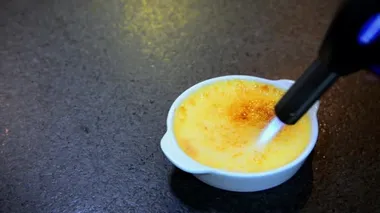 Creme Brulle görüntüsü. Krem karamelize edilmiş şeker. Brüle tatlısı, gaz lambası ile..